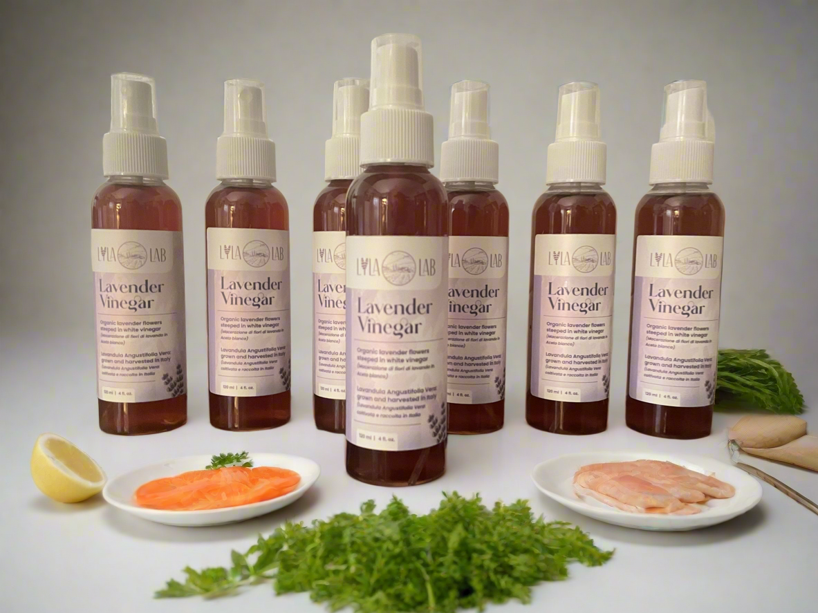 Bottles of lavender vinegar with food items on a table