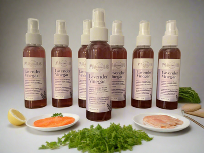 Bottles of lavender vinegar with food items on a table