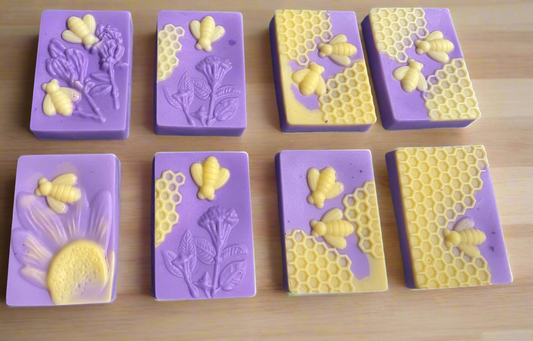 A purple solid body soap bar with a textured surface, resembling a honeycomb pattern, shaped like a heart.